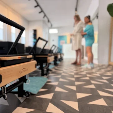 Reformer in de studio van NIDUM Reformer Pilates in Grave met twee vrouwen op de achtergrond